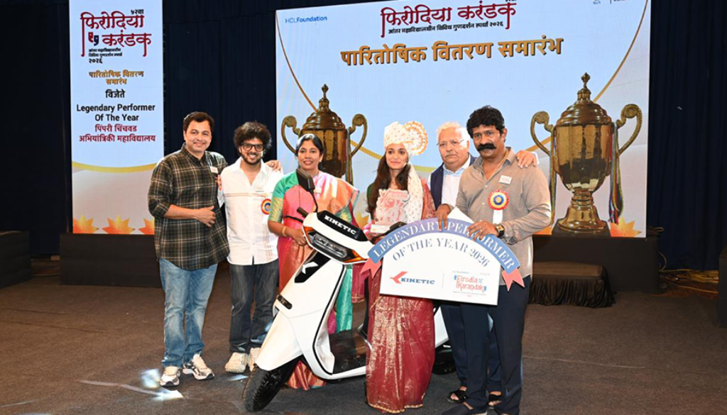 Kinetic awarding top performer at Firodia Karandak with electric scooter prize on stage