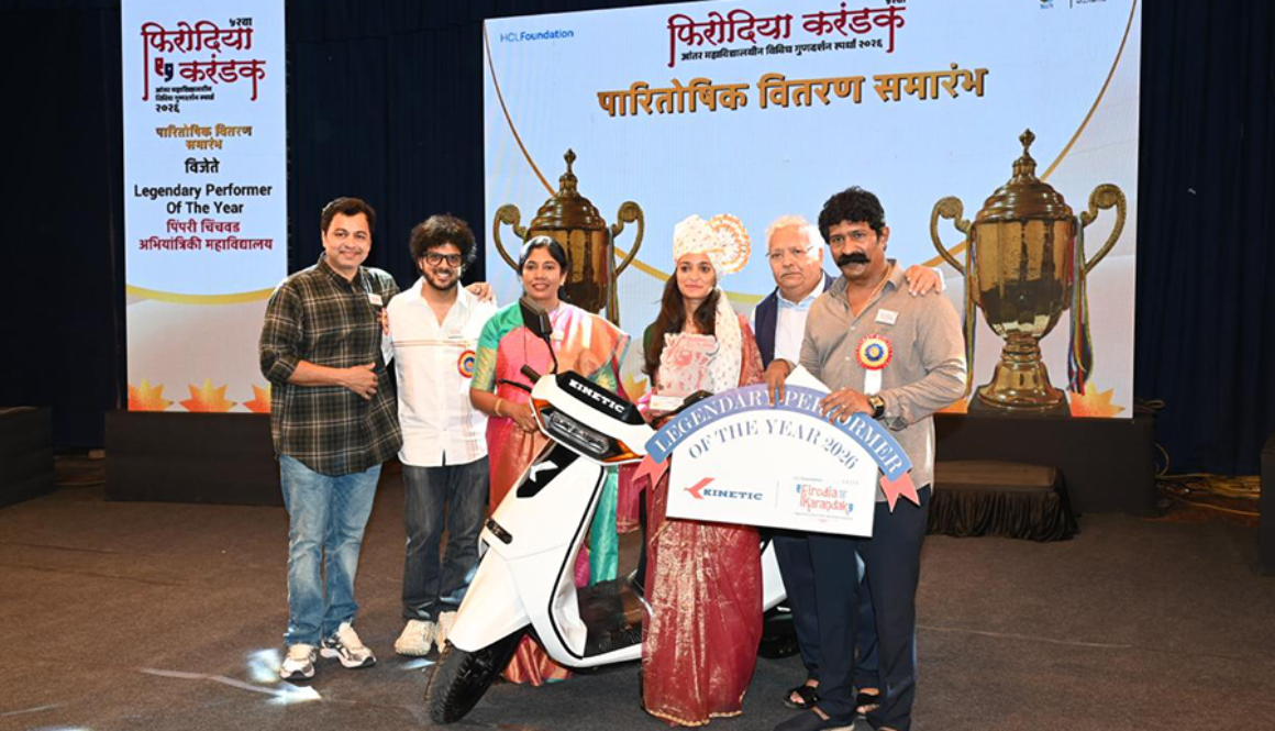 Kinetic awarding top performer at Firodia Karandak with electric scooter prize on stage