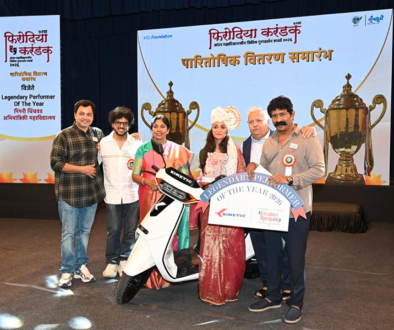Kinetic awarding top performer at Firodia Karandak with electric scooter prize on stage